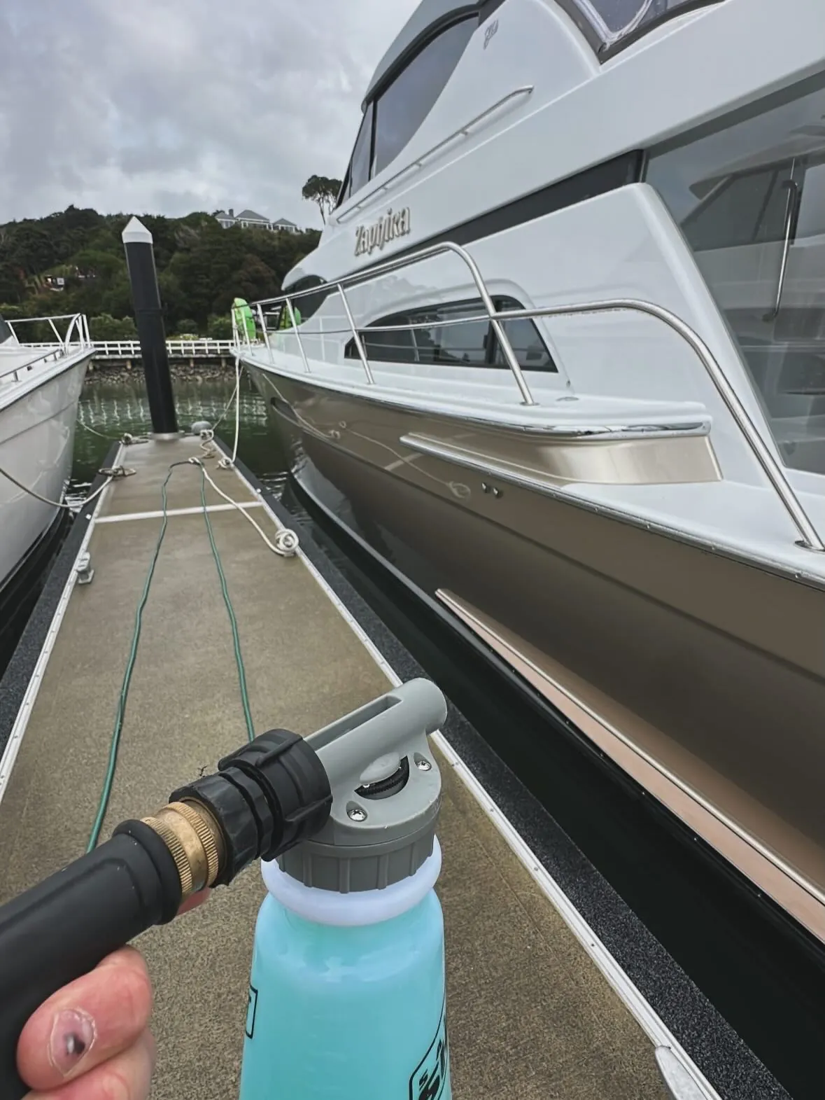 Washing down a launch berth-side at the marina